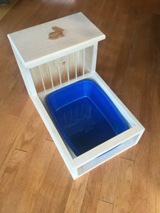 Rabbit hay feeder with dowels in hay area and attached litter tray